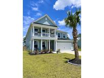 Charming two-story home featuring a spacious porch, rocking chairs, and a well-manicured lawn at 122 Riley Farms Ct, Summerville, SC 29486