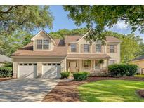 Charming two-story home with a manicured lawn, attached two-car garage, and inviting front porch at 1308 Wild Olive Dr, Mount Pleasant, SC 29464