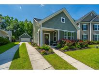 Charming home with a well-manicured lawn, colorful flowerbeds, and a convenient detached garage at 1607 Roustabout Way, Charleston, SC 29414