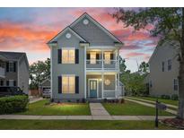 Charming two-story home features a welcoming porch and balcony with nicely manicured landscaping at 1844 Hubbell Dr, Mount Pleasant, SC 29466