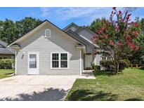 Charming single-story home with light siding, a well-manicured lawn, and a vibrant crape myrtle tree at 2009 Arundel Pl, Mount Pleasant, SC 29464