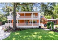 Charming two-story home boasts a double porch and lush landscaping, creating a welcoming curb appeal at 2021 Lakeshore Dr, Charleston, SC 29412