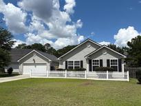 Charming single-story home with a well-manicured lawn and classic white picket fence at 232 Moon Dance Ln, Summerville, SC 29483