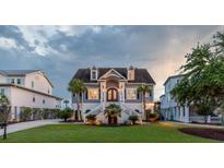 Inviting coastal home featuring a manicured lawn, palm trees and an elevated front entrance at 2668 Crooked Stick Ln, Mount Pleasant, SC 29466