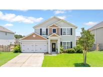 Charming two-story home with attached two car garage and a well-maintained, green front lawn at 302 Mossy Wood Rd, Summerville, SC 29483