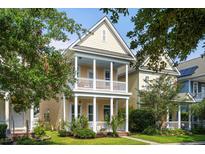 Charming two-story home with a yellow exterior and a inviting front porch with decorative pillars and well manicured lawn at 312 Barberry St, Summerville, SC 29483