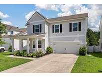Charming two-story home featuring a two car garage, black shutters and a well manicured lawn at 425 W Respite Ln, Summerville, SC 29483