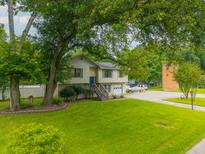 Charming two-story home with a well-manicured lawn and mature trees, with front door and attached garage at 518 Woodward Blvd, Summerville, SC 29483