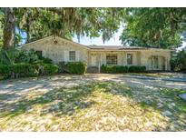 Charming one-story brick home with lush landscaping and mature trees at 5302 Helene Dr, North Charleston, SC 29418