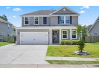 Charming two-story home with gray siding, well-manicured lawn, and a spacious two car attached garage at 536 Man O War Ln, Moncks Corner, SC 29461