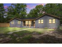 Charming brick home featuring a well-manicured lawn and inviting front porch at 670 Dupre Rd, McClellanville, SC 29458