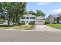 Charming two-story home with green shutters, attached garage, and meticulously manicured front yard at 9253 N Moreto Cir, Summerville, SC 29485