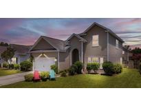 Charming two-story home features a well-maintained lawn, inviting entrance, and attached garage at 112 Worthington Dr, Moncks Corner, SC 29461