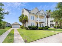 Charming two-story home with a detached garage, landscaped yard, and a cozy front porch at 123 Gaslight Blvd, Summerville, SC 29483