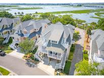 Beautiful two-story coastal home featuring white railings, gray shingles, and elevated design for stunning curb appeal at 1621 Folly Creek Way # D-8, Charleston, SC 29412