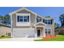 Charming two-story home features a two-car garage, neutral siding, and inviting front porch at 167 Meadow Wood Rd, Summerville, SC 29486