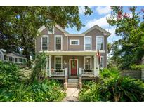 Charming two-story home with a inviting front porch and beautiful landscaping around the property at 171 Queen St, Charleston, SC 29401