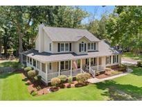 Charming two-story home featuring a spacious porch, manicured lawn, and beautiful landscaping at 207 Littlejohn St, Summerville, SC 29483