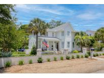 Charming two-story home with a brick wall, front porch, and an American flag at 216 Freeman St, Mount Pleasant, SC 29464