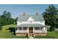 Charming home featuring a metal roof, inviting front porch, and a lush green lawn at 21877 Lowcountry Hwy, Ruffin, SC 29475