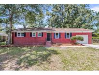 Charming red brick home featuring black shutters and a well-maintained front yard at 245 Clarine Dr, Goose Creek, SC 29445