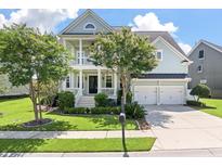 Beautiful two-story home with a spacious front porch, manicured lawn, and attached two-car garage at 3028 River Vista Drive Way, Mount Pleasant, SC 29466
