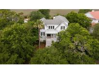 Charming home with a white exterior and a palm tree in the front yard at 31 Seagrass Ln, Isle of Palms, SC 29451