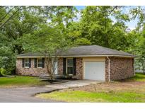 Charming brick home with a well-maintained lawn, mature trees, black shutters, and an attached one-car garage at 400 Tammie Ave, Goose Creek, SC 29445