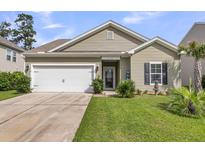 Charming single-story home with a well-manicured lawn, attached garage, and inviting front porch at 519 Tarleton Dr, Summerville, SC 29483