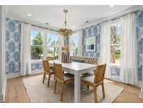Bright dining room features a white table, woven chairs, and a cozy built-in bench at 727 Breakers Reef Ln, Huger, SC 29450