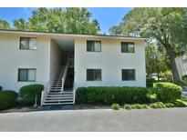 Two-story condo building with open stairwell, neutral siding, and manicured landscaping at 93 Ashley Hall Plantation Rd # 6, Charleston, SC 29407