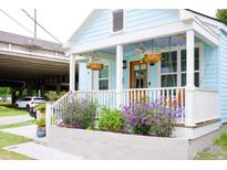 Charming exterior of home with light blue siding, white trim, and flowering plants at 10 Riker St, Charleston, SC 29403