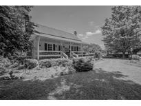 Charming home featuring a covered front porch, white railings, and lush landscaping at 1133 Highway 311, Cross, SC 29436