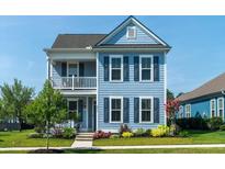Charming two-story home with light blue siding, black shutters, and a quaint second-story porch at 2017 Geranium Ln, Johns Island, SC 29455