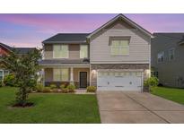 Charming two-story home featuring a well-manicured lawn, stone accents, and a two-car garage at 364 Deep River Rd, Summerville, SC 29486