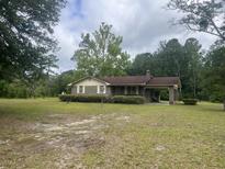 Quaint brick home with a porte-cochère, surrounded by mature trees and a spacious yard at 379 Chestnut Rd, Walterboro, SC 29488