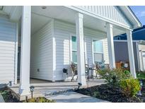 Inviting front porch with stylish seating and well-manicured landscaping adds curb appeal to this charming home at 4407 Palm Shadow Dr, Summerville, SC 29485