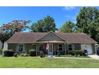 Charming single story brick home with covered porch, flower garden, attached garage and well manicured lawn at 4504 Winterwood Pl, Ladson, SC 29456