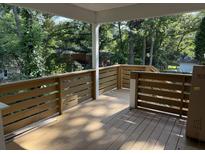 Spacious outdoor deck featuring wood railing and tree-lined backyard, perfect for relaxing and entertaining at 5513 Blackwell Ave # B, North Charleston, SC 29406