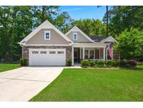 Charming single-Gathering home with an attached two car garage and well-manicured lawn at 6016 Wild Azalea Rd, Summerville, SC 29483