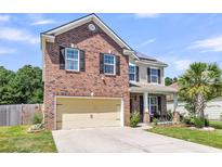 Charming two-story brick home with a two-car garage, manicured lawn, and a welcoming front porch at 7644 High Maple Cir, North Charleston, SC 29418