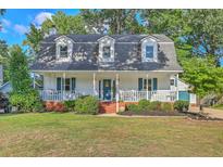 Charming two-story home with a welcoming front porch, manicured lawn and mature trees at 106 Cicero Ct, Goose Creek, SC 29445