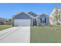 Charming single-Gathering home featuring a two-car garage, well-maintained lawn, and a classic blue exterior at 124 Pontoria Dr, Knightsville, SC 29483
