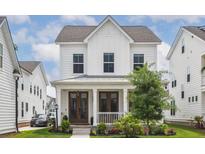Charming two-story home featuring a welcoming front porch, well-manicured lawn, and classic white siding at 1244 Crooked Oak Rd, Charleston, SC 29492