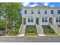 Charming townhomes featuring symmetrical white exteriors, inviting stairs, and lush landscaping at 129 Howard Mary Dr # A, Charleston, SC 29412