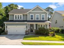 Charming two-story home features an attached garage, manicured lawn, and welcoming front porch at 1300 Enfield Ln, Mount Pleasant, SC 29466