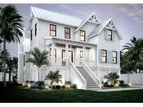 Beautiful two-story home featuring a classic design, inviting front porch, and well-maintained landscaping at 1727 Atlantic Ave, Sullivans Island, SC 29482