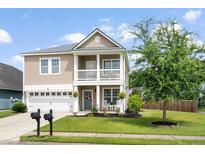 Charming two-story home with a front porch, balcony, manicured lawn, and a two car garage at 200 Topsaw Ln, Moncks Corner, SC 29461