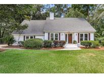 Charming one-story home features a well-maintained lawn and inviting front entrance with decorative shutters at 220 Runnymede Ln, Summerville, SC 29485