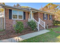Charming brick home with black shutters, manicured landscaping, and a welcoming white railed front porch entrance at 3627 Marginal Rd, Mount Pleasant, SC 29466